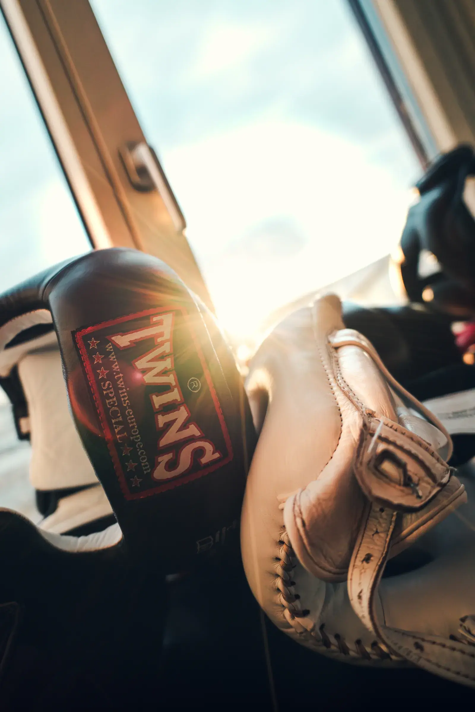 Black and cream Twins boxing gear by a window at America Boxing Gym, backlit by the sun.