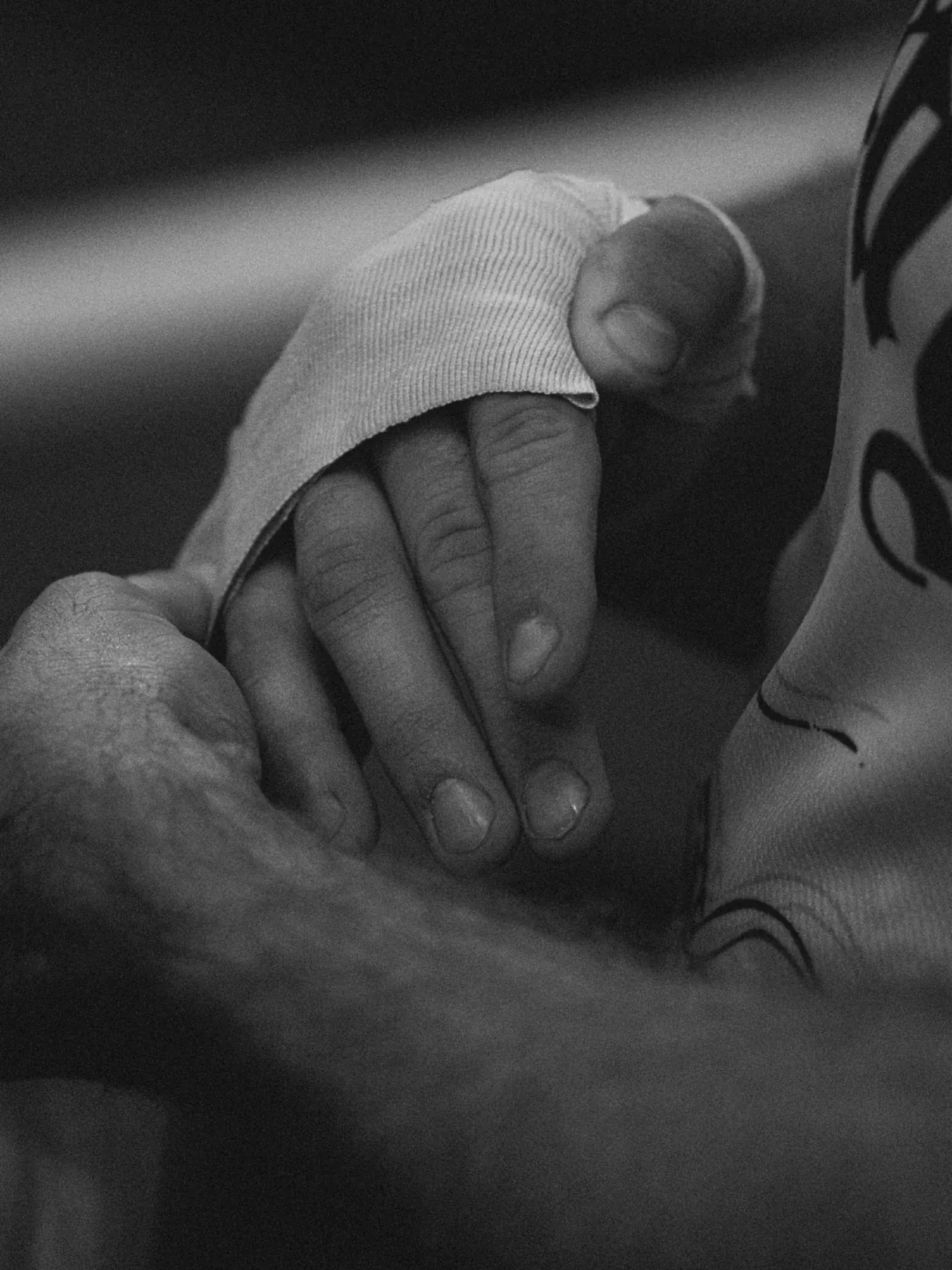 Black-and-white close-up of a hand being wrapped before training.